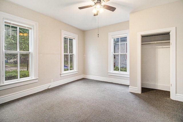 916 Osborne St, Kalamazoo, MI 49001 - unfurnished bedroom featuring multiple windows, dark carpet, a closet, and a ceiling fan