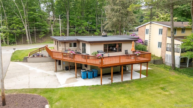 199 Grand Ave, Grand Haven, MI 49417 - rear view of house featuring a deck, a lawn, and a patio