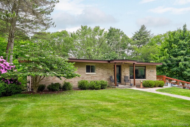 199 Grand Ave, Grand Haven, MI 49417 - view of front of house featuring brick siding, a front lawn, and covered porch