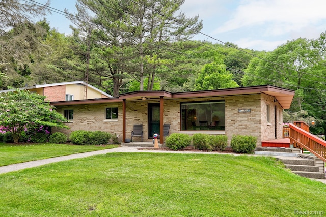 199 Grand Ave, Grand Haven, MI 49417 - view of front of house featuring a front lawn, brick siding, and a porch