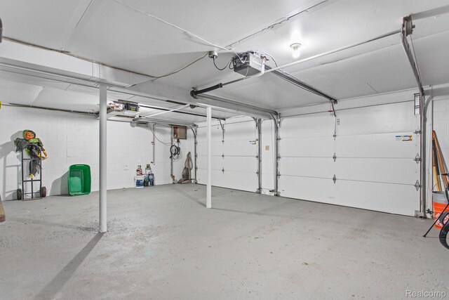 199 Grand Ave, Grand Haven, MI 49417 - garage featuring a garage door opener and concrete block wall