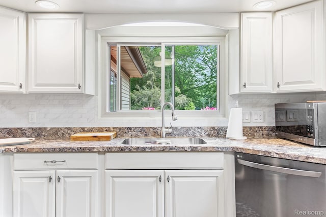 199 Grand Ave, Grand Haven, MI 49417 - kitchen featuring stainless steel appliances, white cabinets, tasteful backsplash, and light stone counters