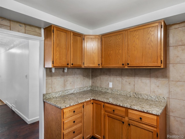 23400 Marlow St, Oak Park, MI 48237 - kitchen featuring dark wood-style flooring, brown cabinets, and light stone counters