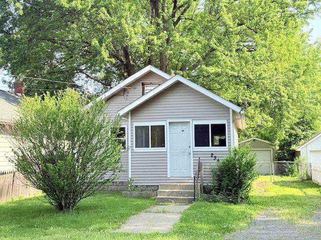 234 Broad St, Michigan Center, MI 49254 - bungalow-style house with a detached garage and entry steps