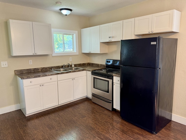 234 Broad St, Michigan Center, MI 49254 - kitchen with freestanding refrigerator, electric stove, dark countertops, and white cabinets