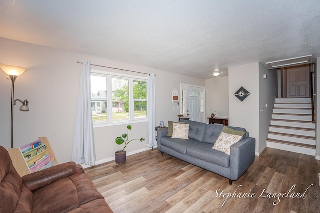 348 Yuba St, Muskegon, MI 49442 - living area featuring wood finished floors, a textured ceiling, stairs, and attic access