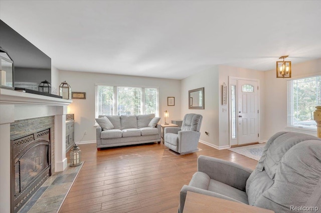737 Camilla Blvd, Lake Orion, MI 48362 - living room featuring a tile fireplace, plenty of natural light, hardwood / wood-style floors, and a chandelier