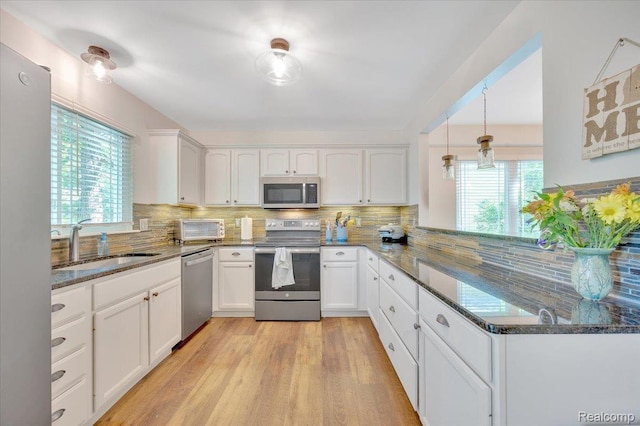 737 Camilla Blvd, Lake Orion, MI 48362 - kitchen featuring stainless steel appliances, dark stone countertops, white cabinets, and tasteful backsplash