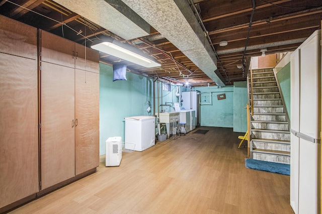 6361 Plainfield Ave, Kalamazoo, MI 49048 - below grade area featuring fridge, wood finished floors, and stairs