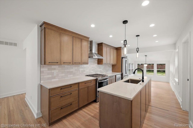 15589 Kirkshire Ave, Beverly Hills, MI 48025 - kitchen with wall chimney exhaust hood, appliances with stainless steel finishes, tasteful backsplash, light wood-style flooring, and a kitchen island with sink