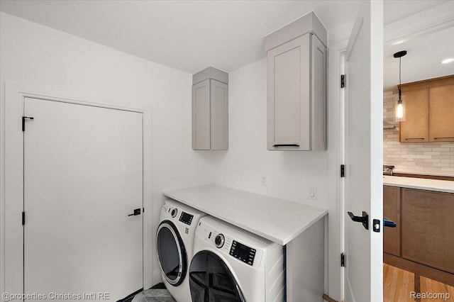 15589 Kirkshire Ave, Beverly Hills, MI 48025 - laundry room with cabinet space, washing machine and dryer, and light wood-style flooring