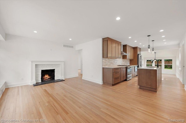 15589 Kirkshire Ave, Beverly Hills, MI 48025 - kitchen with appliances with stainless steel finishes, wall chimney exhaust hood, open floor plan, light wood-style flooring, and recessed lighting