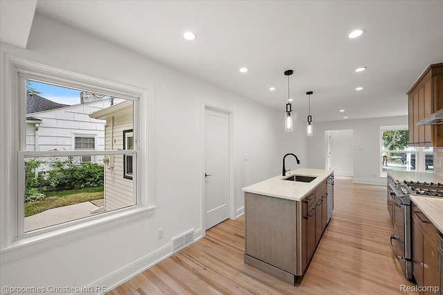 15589 Kirkshire Ave, Beverly Hills, MI 48025 - kitchen featuring appliances with stainless steel finishes, recessed lighting, light wood finished floors, an island with sink, and pendant lighting