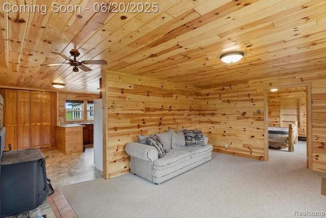18031 State Highway M28, Newberry, MI 49868 - unfurnished living room featuring wood ceiling, wooden walls, a ceiling fan, a wood stove, and carpet