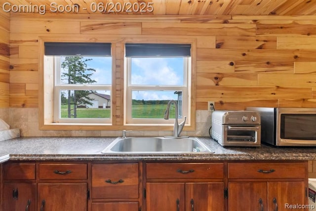 18031 State Highway M28, Newberry, MI 49868 - kitchen with stainless steel microwave, brown cabinets, dark countertops, wooden ceiling, and wood walls