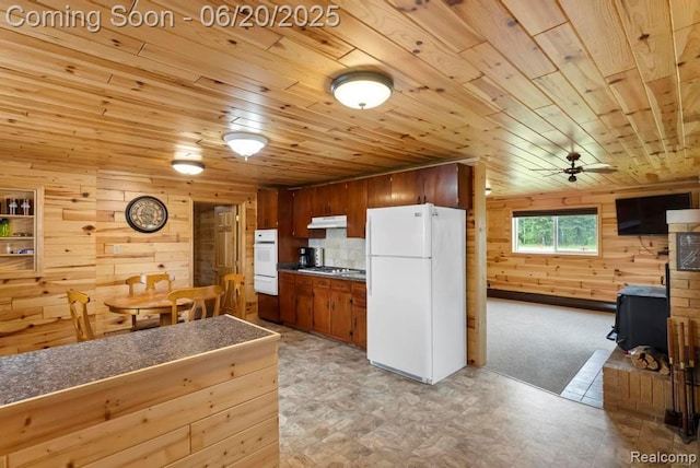 18031 State Highway M28, Newberry, MI 49868 - kitchen with white appliances, wood walls, a wood stove, under cabinet range hood, and wooden ceiling