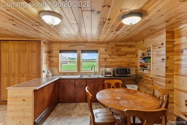 18031 State Highway M28, Newberry, MI 49868 - kitchen featuring wooden ceiling, stainless steel microwave, wooden walls, a peninsula, and brown cabinets