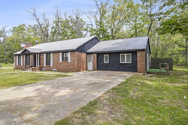 6236 Arbutus, Idlewild, MI 49642 - view of front of house with concrete driveway, a chimney, a front yard, a metal roof, and brick siding