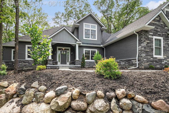 5950 Mountain Top Dr, Brighton, MI 48116 - craftsman-style house featuring stone siding, roof with shingles, and a porch