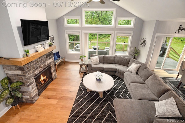 5950 Mountain Top Dr, Brighton, MI 48116 - living area featuring a stone fireplace, light wood-type flooring, vaulted ceiling, and a ceiling fan
