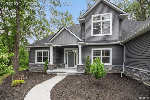 5950 Mountain Top Dr, Brighton, MI 48116 - view of front of home with roof with shingles, covered porch, stone siding, and board and batten siding