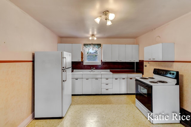 8974 Park St, Montague, MI 49437 - kitchen with white appliances, white cabinetry, light floors, and crown molding