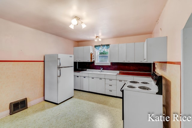 8974 Park St, Montague, MI 49437 - kitchen featuring white appliances, white cabinets, and light countertops