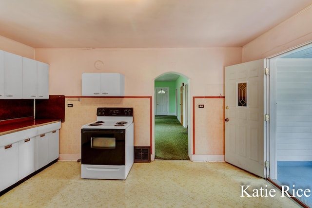 8974 Park St, Montague, MI 49437 - kitchen featuring range with electric stovetop, arched walkways, white cabinetry, and light flooring