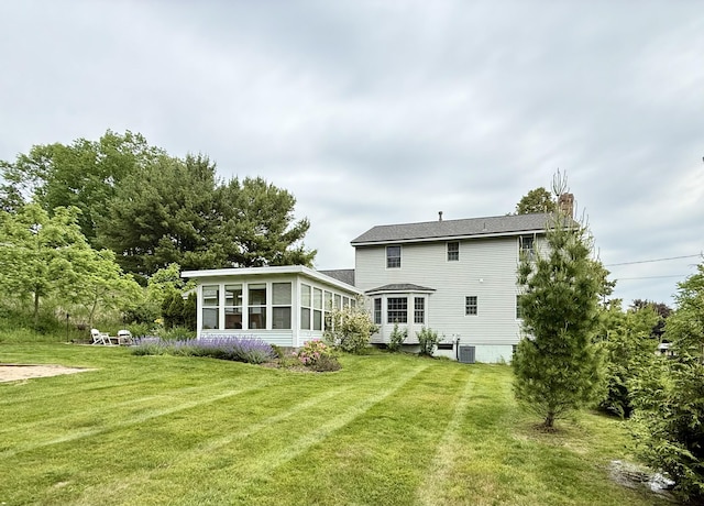 334 Terrill Ave, Grand Haven, MI 49417 - back of house featuring a sunroom, a chimney, and a lawn