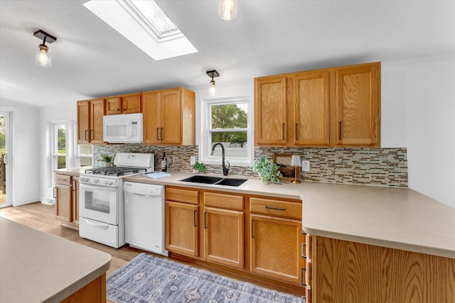 6626 Dennison Rd, Plainwell, MI 49080 - kitchen with white appliances, a skylight, light countertops, and plenty of natural light