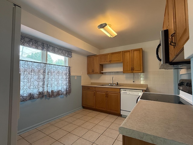216 Bradley St, Dowagiac, MI 49047 - kitchen featuring white appliances, backsplash, light tile patterned floors, brown cabinets, and light countertops