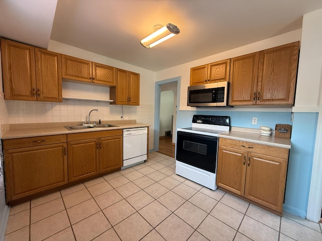 216 Bradley St, Dowagiac, MI 49047 - kitchen with stainless steel microwave, dishwasher, electric stove, light countertops, and light tile patterned floors