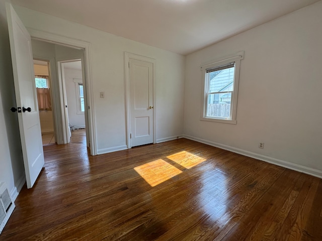 216 Bradley St, Dowagiac, MI 49047 - unfurnished bedroom with dark wood-style flooring and baseboards