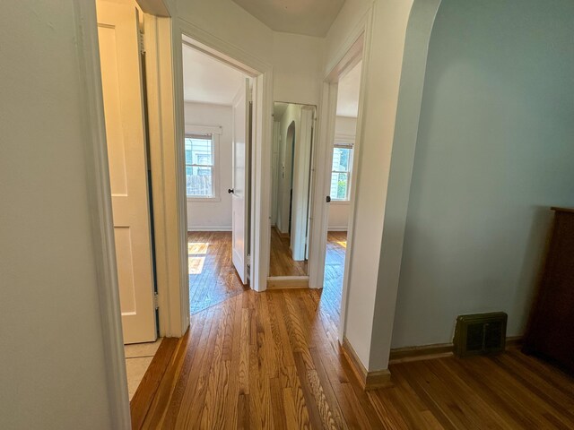 216 Bradley St, Dowagiac, MI 49047 - hallway featuring healthy amount of natural light, wood finished floors, and arched walkways