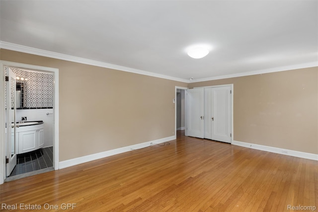 542 Cadieux Rd, Grosse Pointe, MI 48230 - unfurnished bedroom with light wood-style floors, crown molding, a closet, ensuite bathroom, and a chandelier