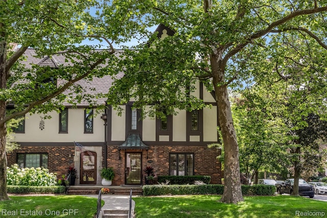 542 Cadieux Rd, Grosse Pointe, MI 48230 - view of front of house with stucco siding, brick siding, and a front yard
