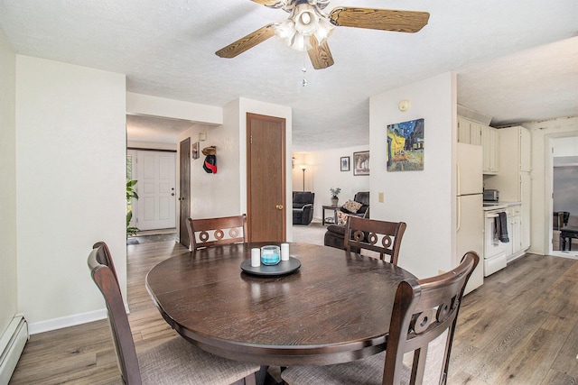 5890 N Oceana Dr, Hart, MI 49420 - dining space featuring baseboard heating, wood finished floors, and ceiling fan