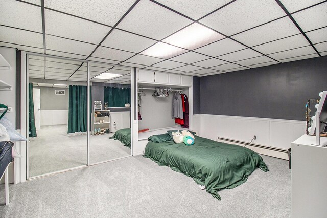 5890 N Oceana Dr, Hart, MI 49420 - carpeted bedroom featuring a baseboard heating unit, a wainscoted wall, a paneled ceiling, and a closet