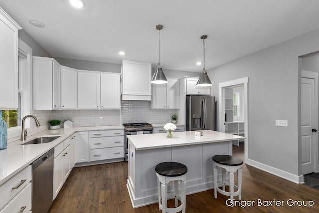 11569 Sessions Woods Dr W, Grand Rapids, MI 49534 - kitchen with appliances with stainless steel finishes, decorative backsplash, custom range hood, white cabinets, and a breakfast bar