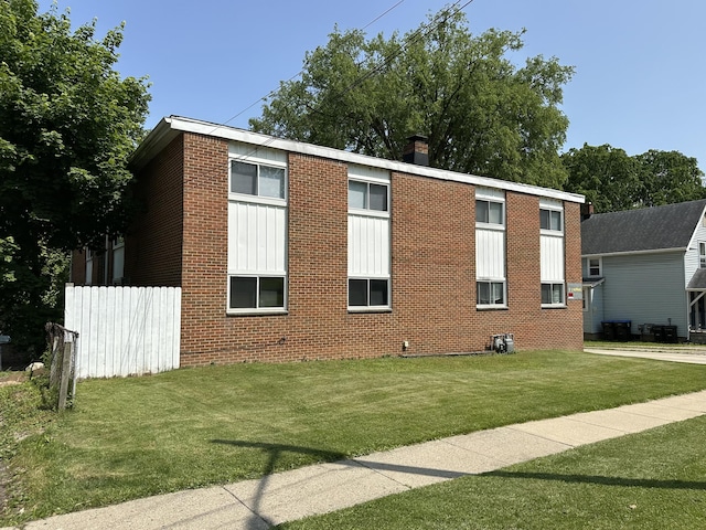 7 S Normal St, Ypsilanti, MI 48197 - view of side of property featuring brick siding, a lawn, and a chimney