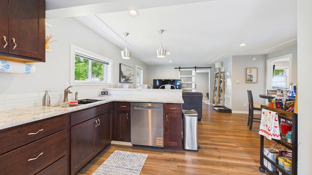 1204 Witham Rd, Muskegon, MI 49445 - kitchen featuring stainless steel dishwasher, a barn door, wood finished floors, a peninsula, and light stone countertops