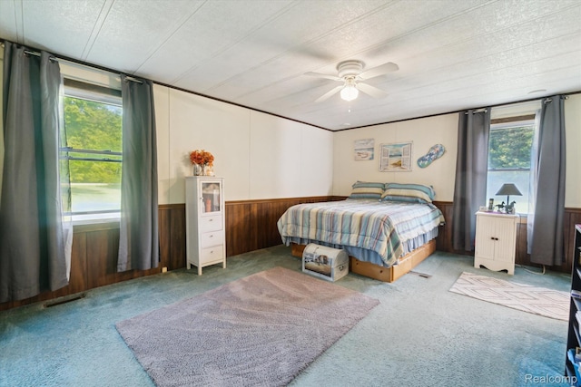 8031 Vassar Rd, Millington, MI 48746 - bedroom featuring carpet, wainscoting, wood walls, a textured ceiling, and a ceiling fan