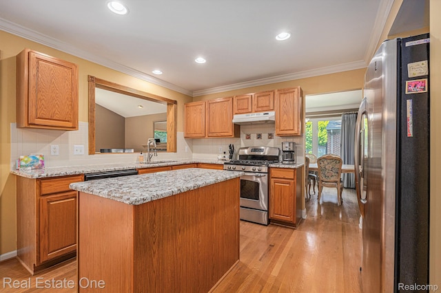 2842 Manorwood Dr, Troy, MI 48085 - kitchen featuring stainless steel appliances, under cabinet range hood, light wood-type flooring, a center island, and crown molding