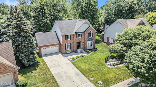 2842 Manorwood Dr, Troy, MI 48085 - view of front facade featuring a garage, driveway, brick siding, and a front lawn