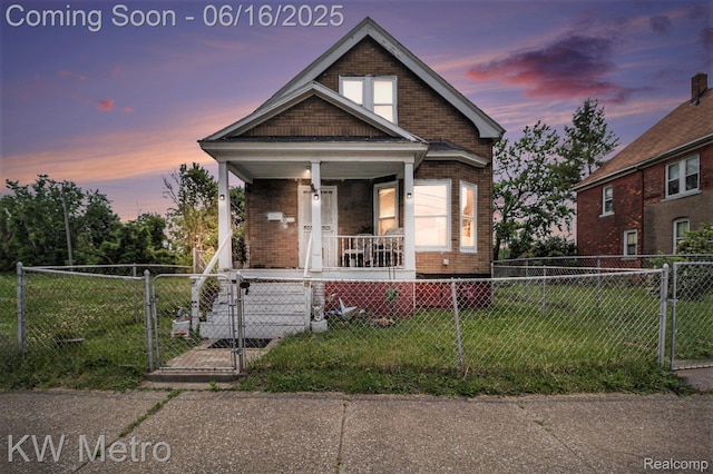 3620 Holborn St, Detroit, MI 48211 - view of front of home with covered porch, a gate, brick siding, and a fenced front yard