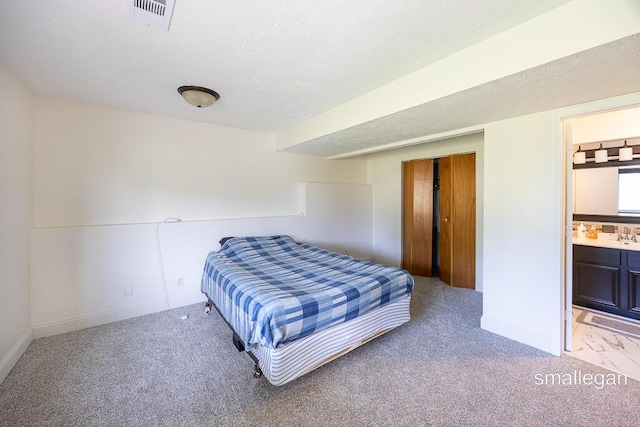 1591 Lillyview Ct SW, Wyoming, MI 49509 - bedroom featuring light colored carpet, connected bathroom, a textured ceiling, and a closet