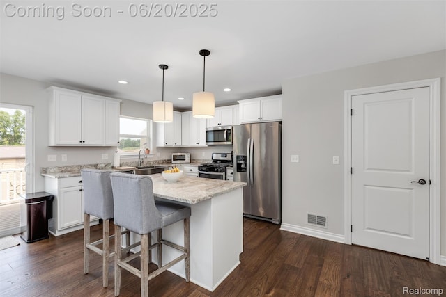 3923 Maple Ln, Auburn Hills, MI 48326 - kitchen featuring appliances with stainless steel finishes, dark wood finished floors, white cabinets, a center island, and recessed lighting