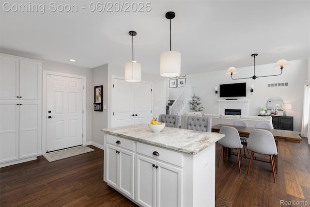 3923 Maple Ln, Auburn Hills, MI 48326 - kitchen with white cabinetry, dark wood-type flooring, pendant lighting, a fireplace, and a center island