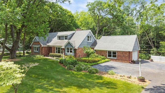 26165 Hidden Valley Dr, Farmington Hills, MI 48331 - view of front of property featuring brick siding, a chimney, driveway, and view of scattered trees