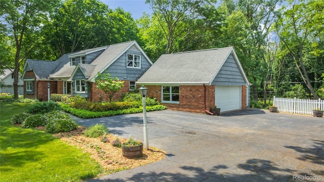 26165 Hidden Valley Dr, Farmington Hills, MI 48331 - view of front of house featuring brick siding, asphalt driveway, an outdoor structure, a detached garage, and a shingled roof